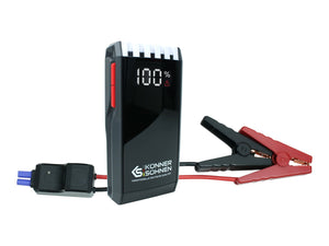 Könner & Söhnen KS JS-1400 portable car jump starter with heavy-duty battery booster clamps, displaying 100% charge on the digital screen